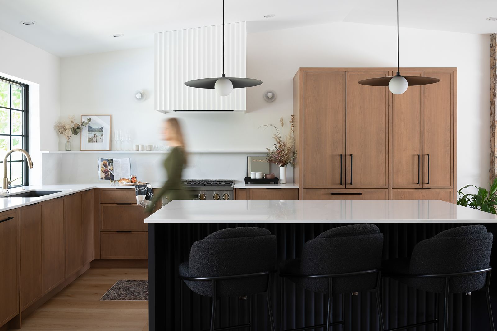 rebecca foster walking through renovated modern kitchen.