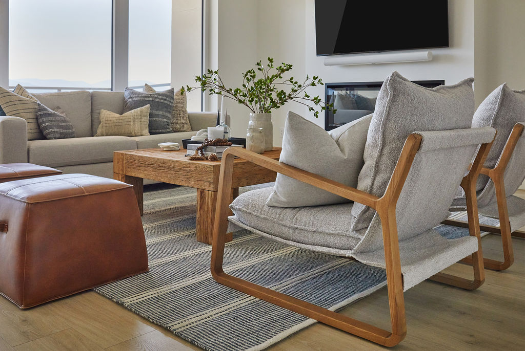 modern living room after home improvement with blue rug grey chairs and rustic coffee table