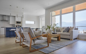 Modern kitchen and living room after home improvement with blue accents and lake view.